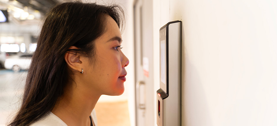 Person using a facial recognition scanner for access.