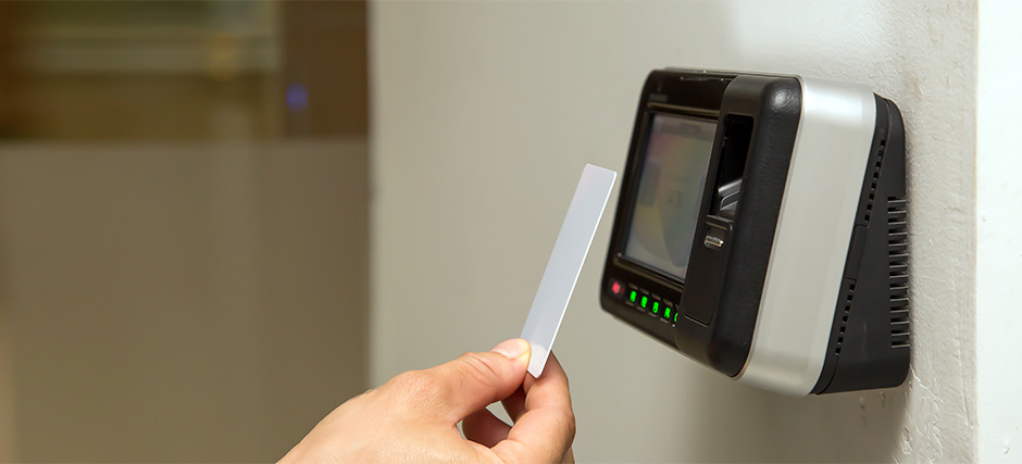 Hand scanning access card at an office time clock terminal.